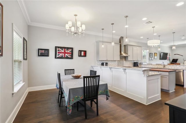 kitchen featuring kitchen peninsula, a wealth of natural light, and wall chimney exhaust hood