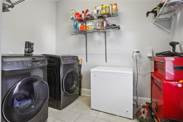 washroom with light tile patterned floors and washing machine and clothes dryer