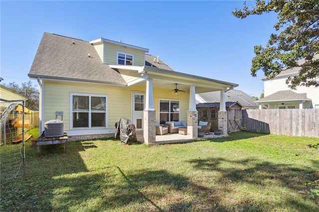 back of house with central AC, a patio area, a yard, and an outdoor living space