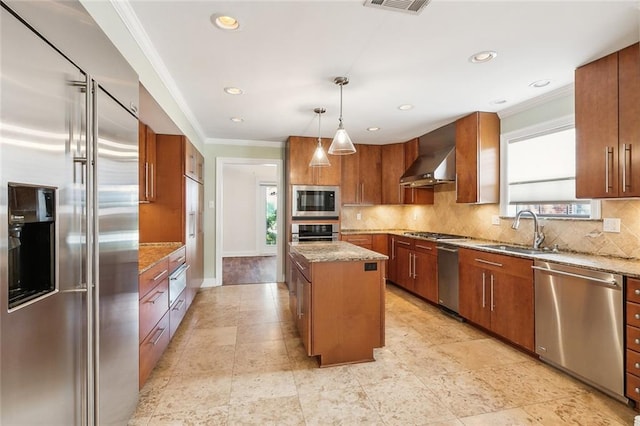 kitchen featuring a center island, sink, built in appliances, a wealth of natural light, and decorative light fixtures