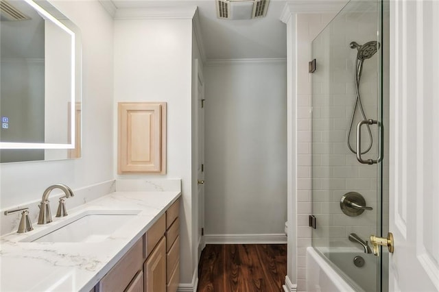 bathroom with enclosed tub / shower combo, crown molding, vanity, and wood-type flooring