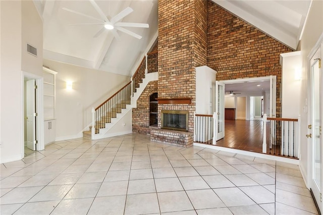 unfurnished living room featuring light tile patterned floors, high vaulted ceiling, and a brick fireplace