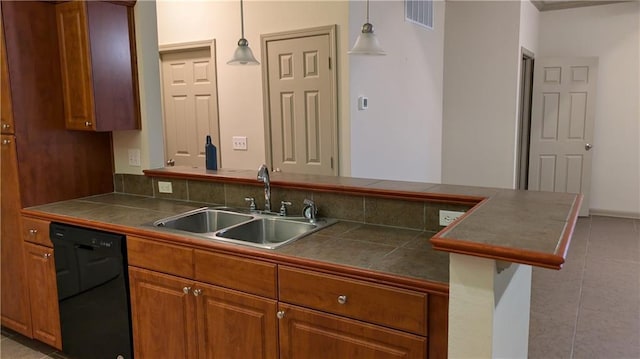 kitchen with pendant lighting, sink, black dishwasher, light tile patterned floors, and kitchen peninsula