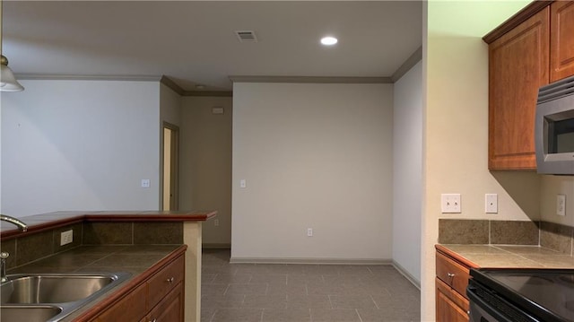 kitchen featuring ornamental molding, sink, and tile counters