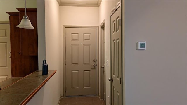 hall featuring light tile patterned floors and ornamental molding