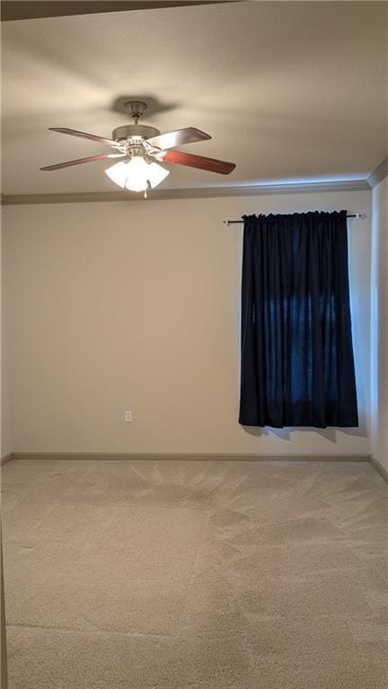 carpeted empty room featuring ornamental molding and ceiling fan