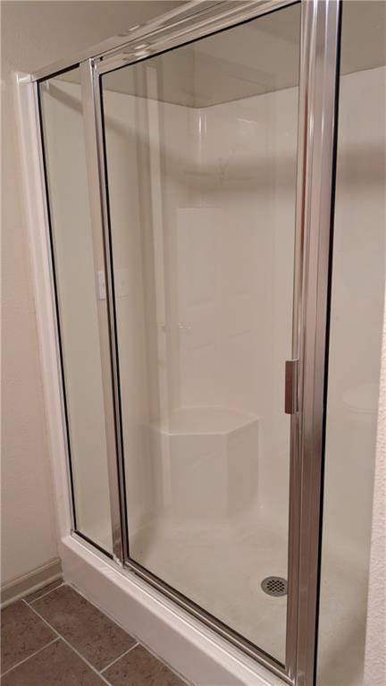 bathroom featuring a shower with door and tile patterned floors