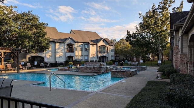 view of swimming pool featuring pool water feature, a patio area, and a jacuzzi