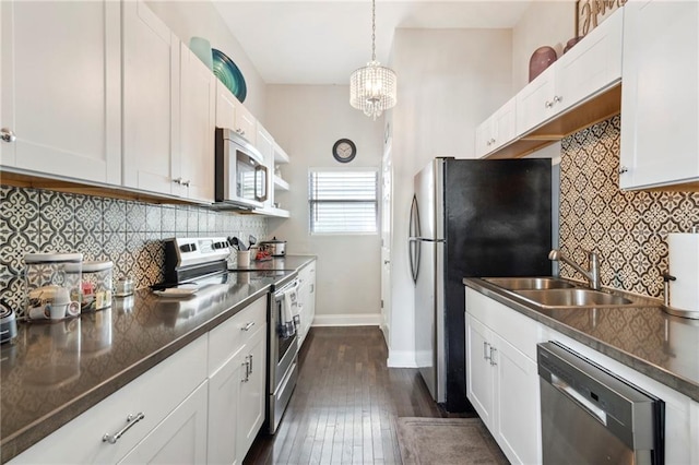 kitchen featuring sink, white cabinets, decorative light fixtures, and appliances with stainless steel finishes