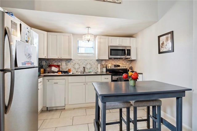 kitchen with white cabinets, sink, appliances with stainless steel finishes, and tasteful backsplash