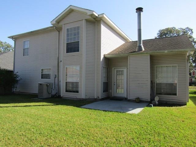 rear view of house featuring central AC unit, a patio area, and a lawn