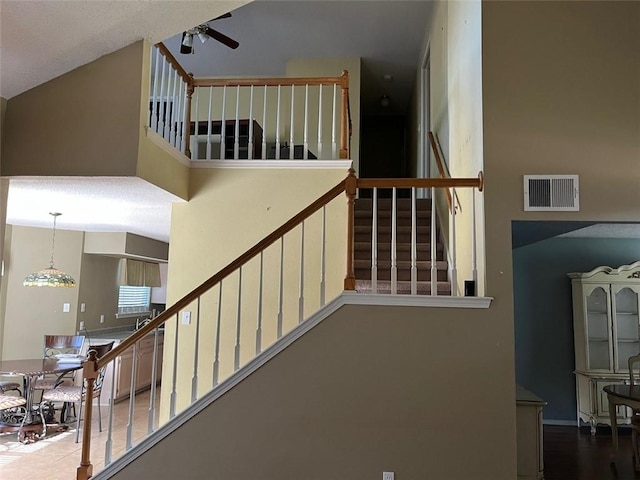 stairs featuring ceiling fan, vaulted ceiling, and hardwood / wood-style flooring