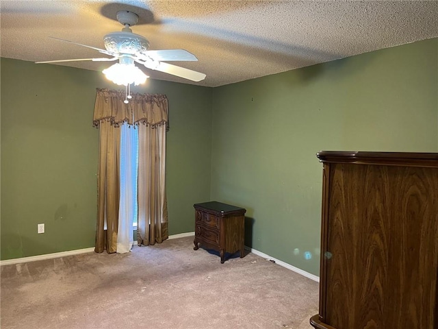 interior space featuring ceiling fan, light colored carpet, and a textured ceiling