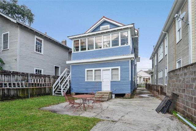 rear view of house with a patio area and a yard