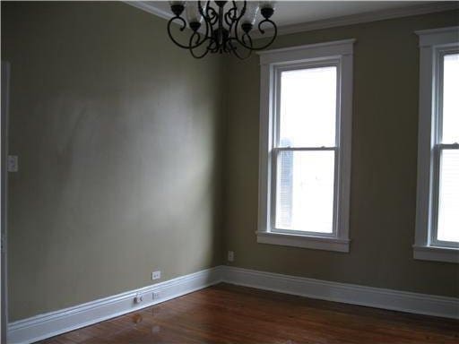 1127 Fern St, New Orleans, LA 70118 - empty room featuring a chandelier, crown molding, plenty of natural light, baseboards, and dark wood-style floors