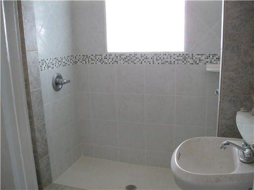 bathroom with sink and tiled shower