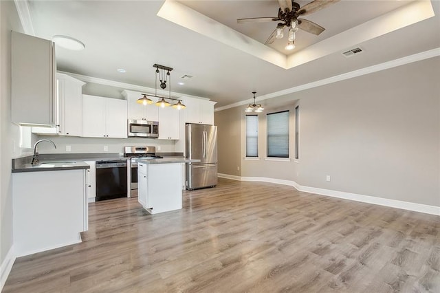 kitchen with a kitchen island, visible vents, hanging light fixtures, appliances with stainless steel finishes, and a tray ceiling