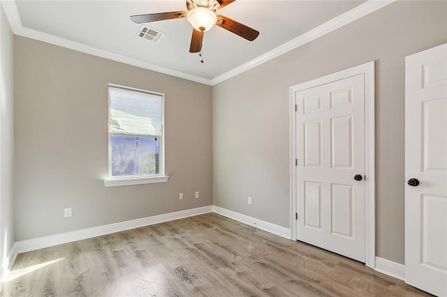 unfurnished bedroom featuring ornamental molding, visible vents, light wood-style flooring, and baseboards