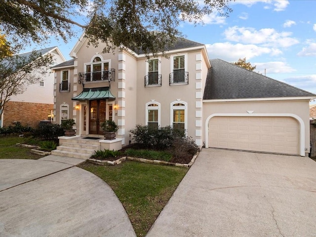 view of front of home with a garage, a balcony, and cooling unit