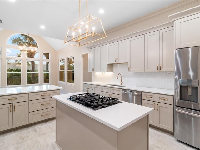 kitchen featuring stainless steel appliances, sink, an inviting chandelier, a center island, and hanging light fixtures