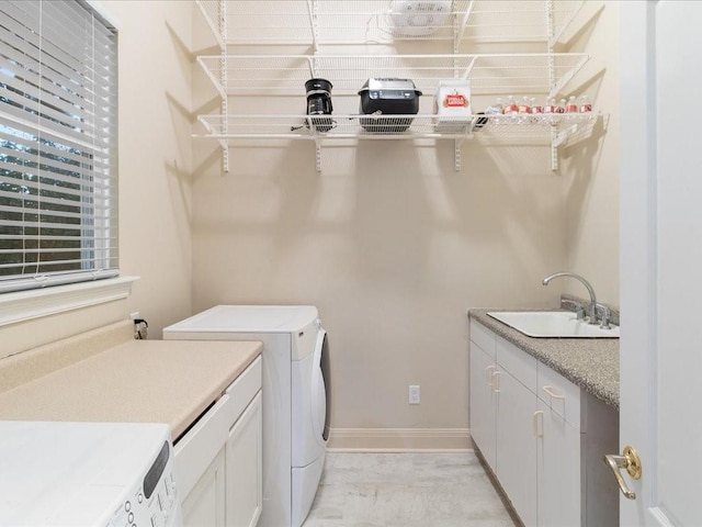 laundry area with cabinets, sink, and washer and dryer