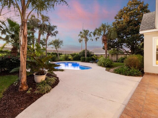 pool at dusk with a patio