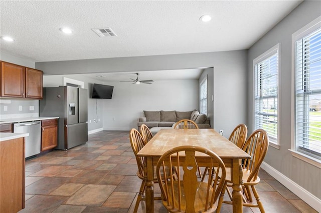 dining room featuring a wealth of natural light, ceiling fan, and a textured ceiling