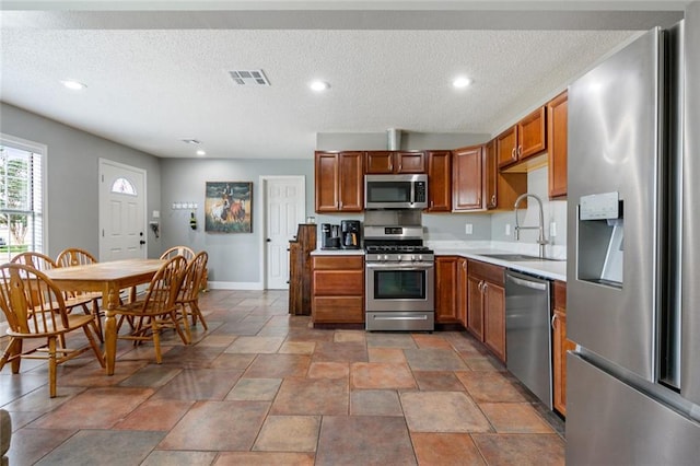 kitchen with sink, stainless steel appliances, and a textured ceiling