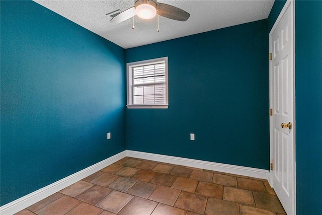 tiled spare room featuring ceiling fan and a textured ceiling