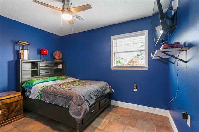 bedroom with tile patterned flooring, a textured ceiling, and ceiling fan