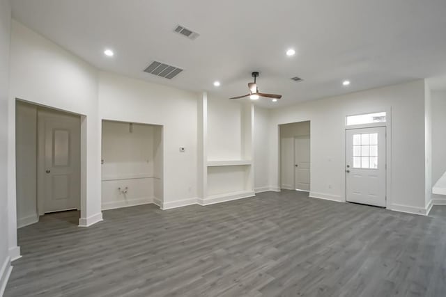 unfurnished living room featuring ceiling fan and dark wood-type flooring