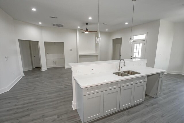 kitchen featuring sink, hanging light fixtures, ceiling fan, gray cabinets, and an island with sink