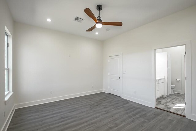 unfurnished bedroom with connected bathroom, a closet, ceiling fan, and dark wood-type flooring