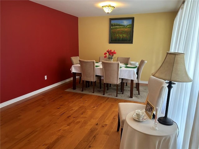 dining space featuring baseboards and wood finished floors