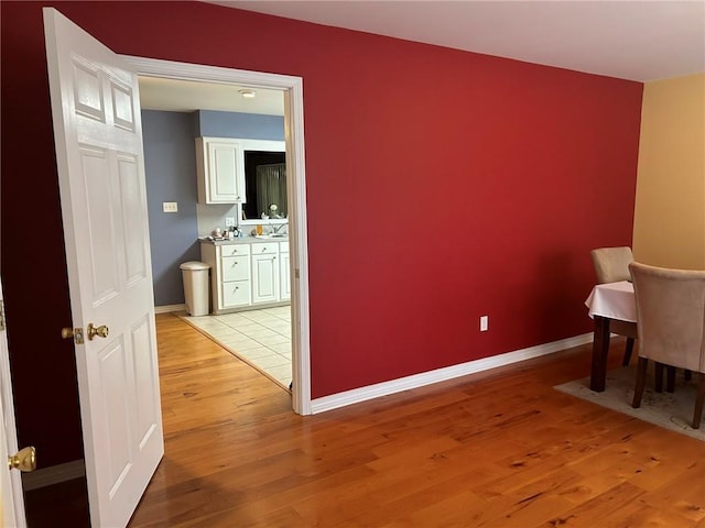 living area with baseboards and light wood finished floors