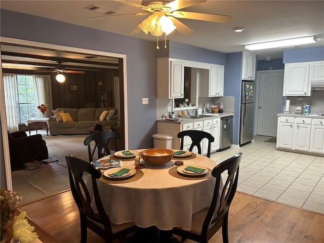 dining space featuring visible vents, light wood-style flooring, and a ceiling fan