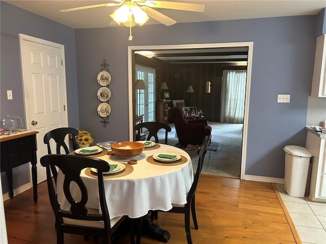 dining area featuring baseboards, light wood finished floors, and ceiling fan