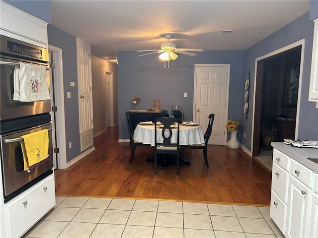 dining space featuring light tile patterned floors, baseboards, visible vents, and ceiling fan