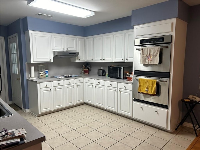 kitchen with gas cooktop, visible vents, white cabinets, under cabinet range hood, and double oven