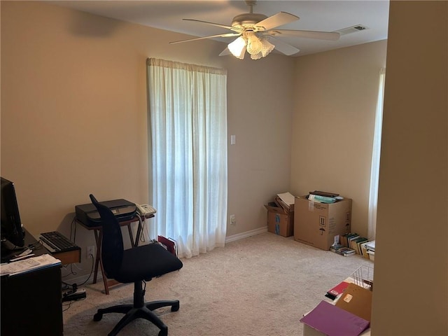 carpeted home office with a ceiling fan and visible vents