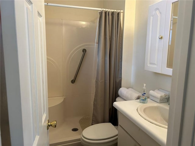 bathroom featuring toilet, a stall shower, and vanity