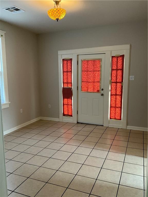 9009 Belfast St, New Orleans, LA 70118 - entryway featuring light tile patterned floors and baseboards