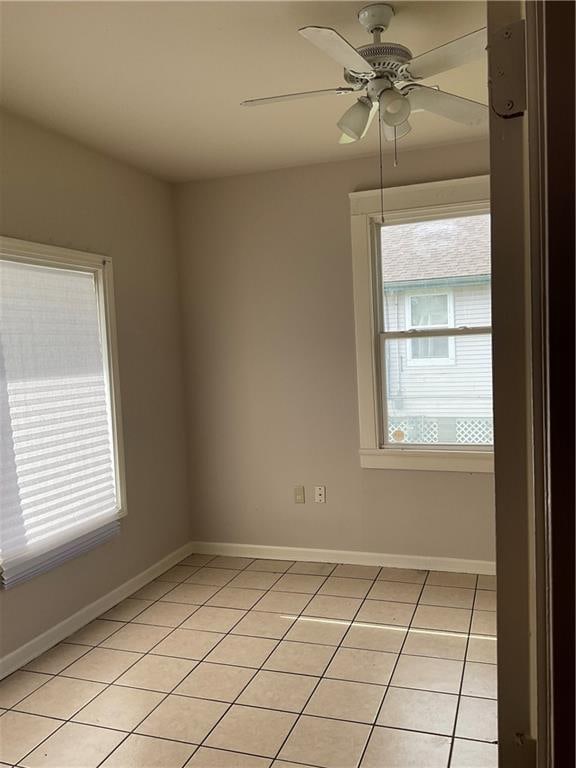 tiled spare room featuring ceiling fan