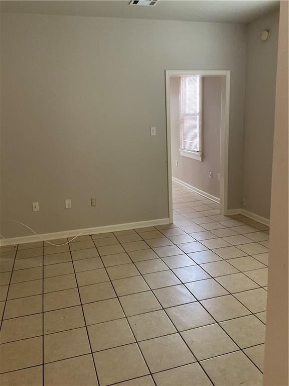 9009 Belfast St, New Orleans, LA 70118 - spare room featuring light tile patterned floors and baseboards