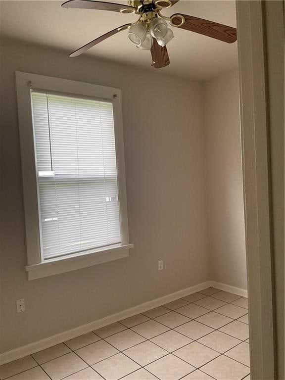 tiled spare room featuring ceiling fan