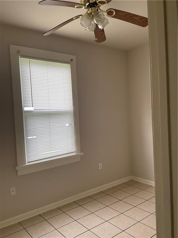 9009 Belfast St, New Orleans, LA 70118 - empty room featuring a ceiling fan, light tile patterned flooring, and baseboards