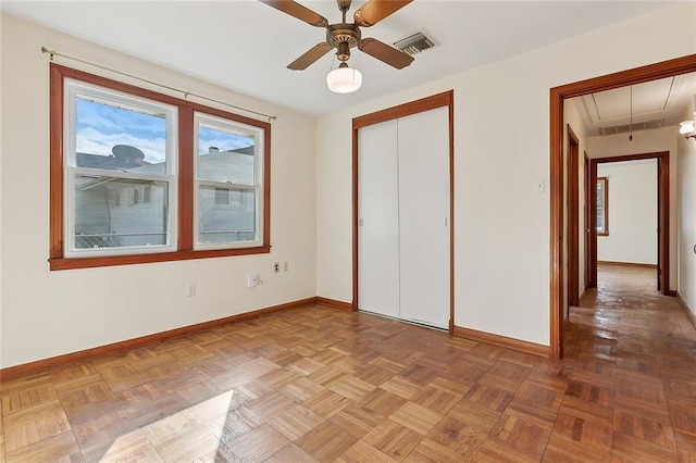 unfurnished bedroom with ceiling fan, a closet, and parquet flooring