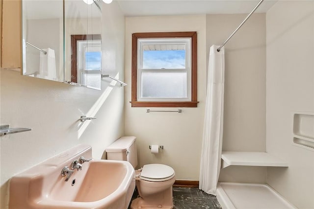 bathroom with a shower with shower curtain, toilet, and sink