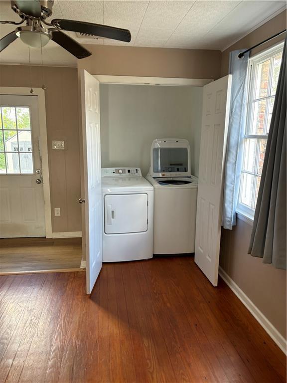 clothes washing area featuring wood-type flooring, ceiling fan, and washing machine and clothes dryer