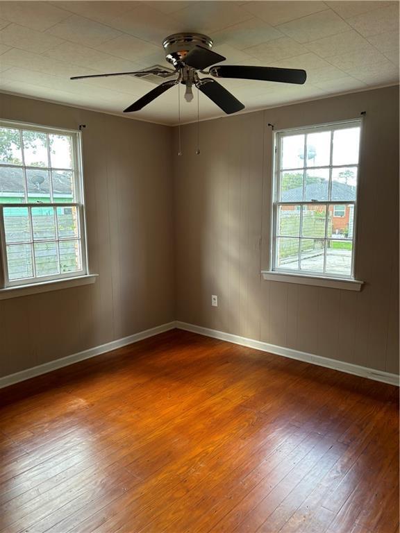 empty room featuring hardwood / wood-style floors, a wealth of natural light, and ceiling fan